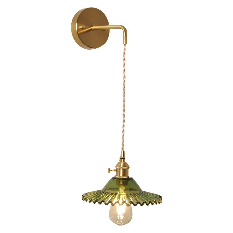Retro brass lotus wall lamp with glass shade mounted on a beige wall, showcasing its copper arm and layered design.