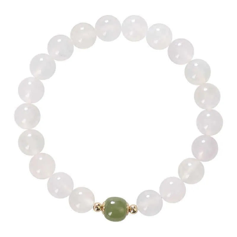 Handmade white agate crystal bracelet with cinnabar details on a wrist, showing 8mm bead size.