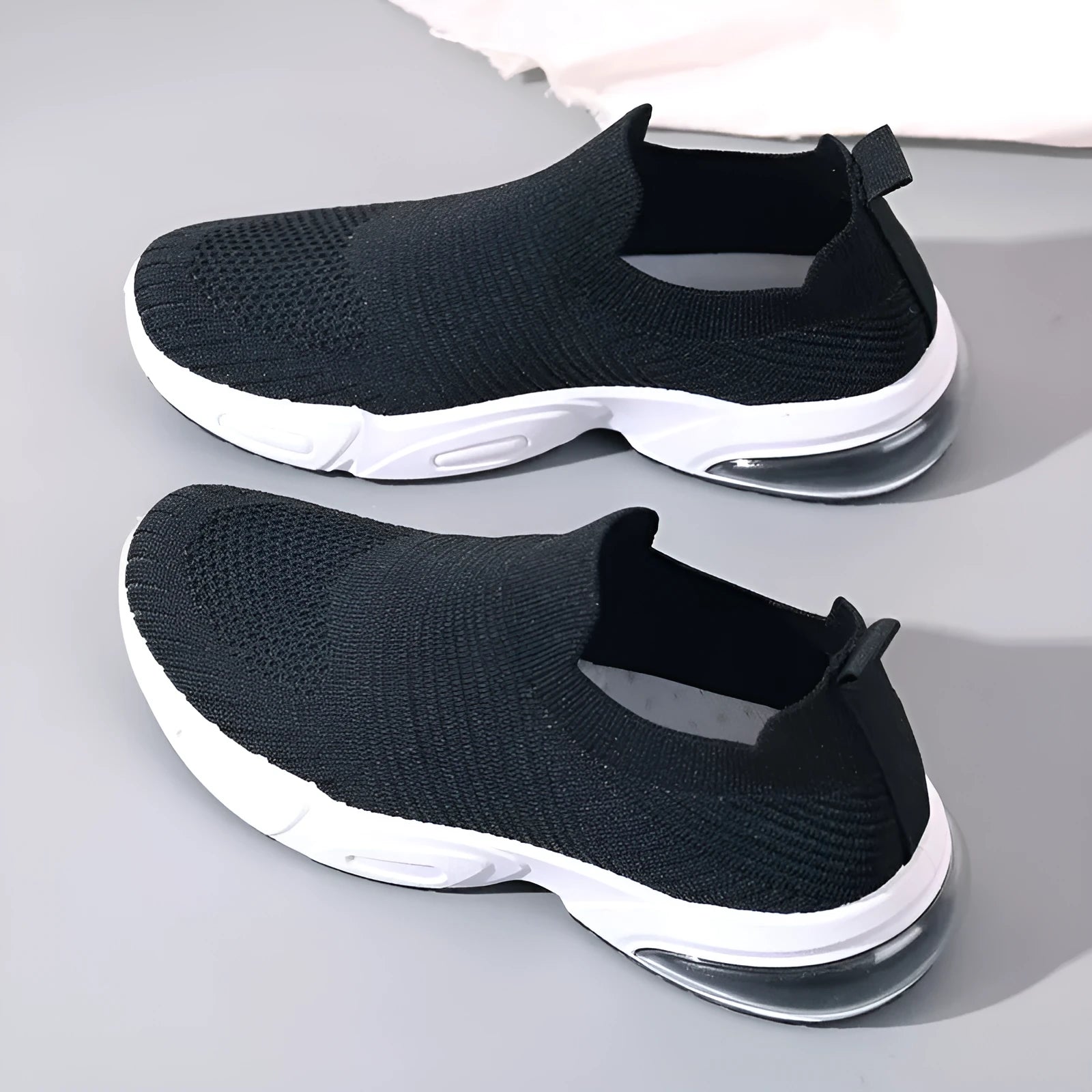 Lightweight black slip-on sock shoes with a low-top design and textured PVC sole.