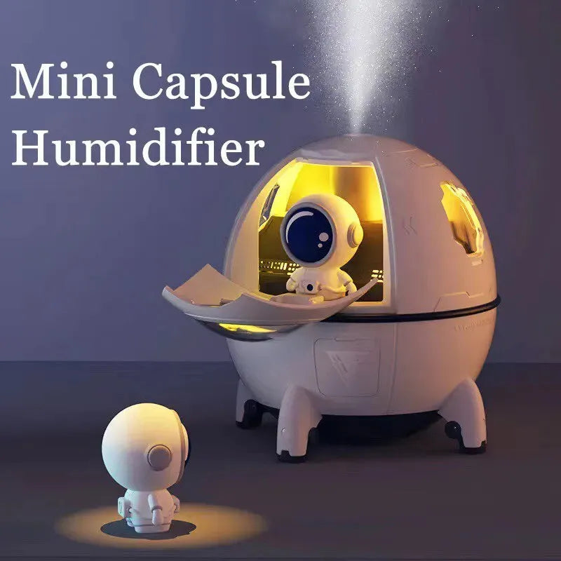 Light purple astronaut-shaped USB desktop humidifier with colourful LED light on a desk.