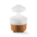 Wood grain rain cloud shaped humidifier and essential oil diffuser with night light on a table.