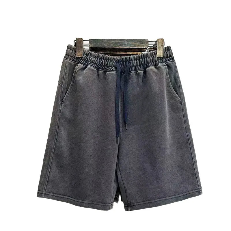 Man wearing loose-fit distressed cotton shorts in a solid colour.