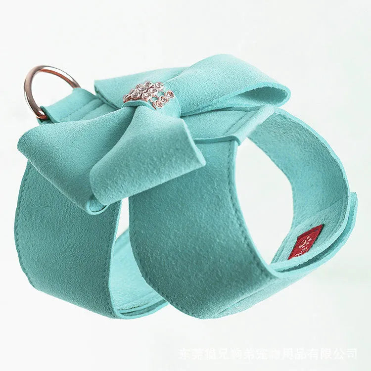 A pink microfiber dog chest strap with a white bowknot, showing the adjustable size buckles.