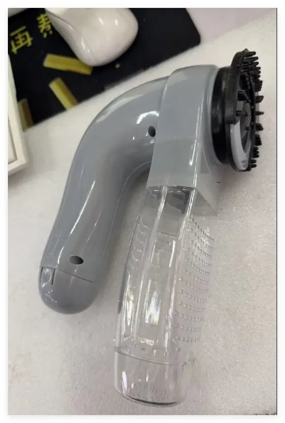 Grey portable electric pet hair removal vacuum with soft rubber grooming head.