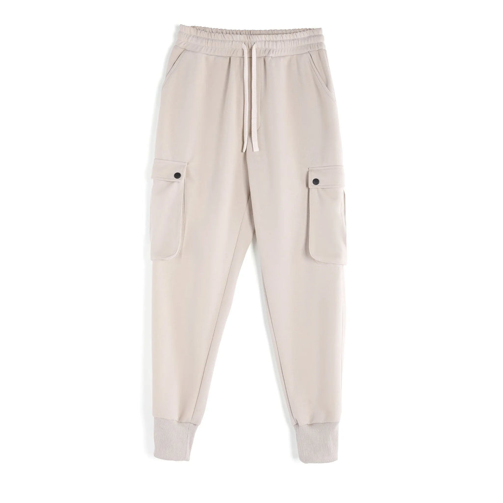 Men's loose-fit apricot coloured cotton sports trousers with an ankle tie and side pockets on a neutral background.