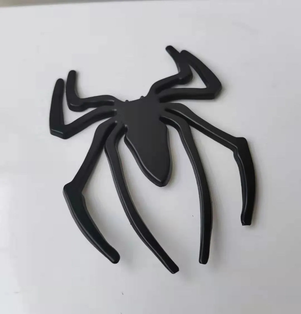 Three-dimensional metal spider car bumper sticker in gold, silver, black, and red colour options.