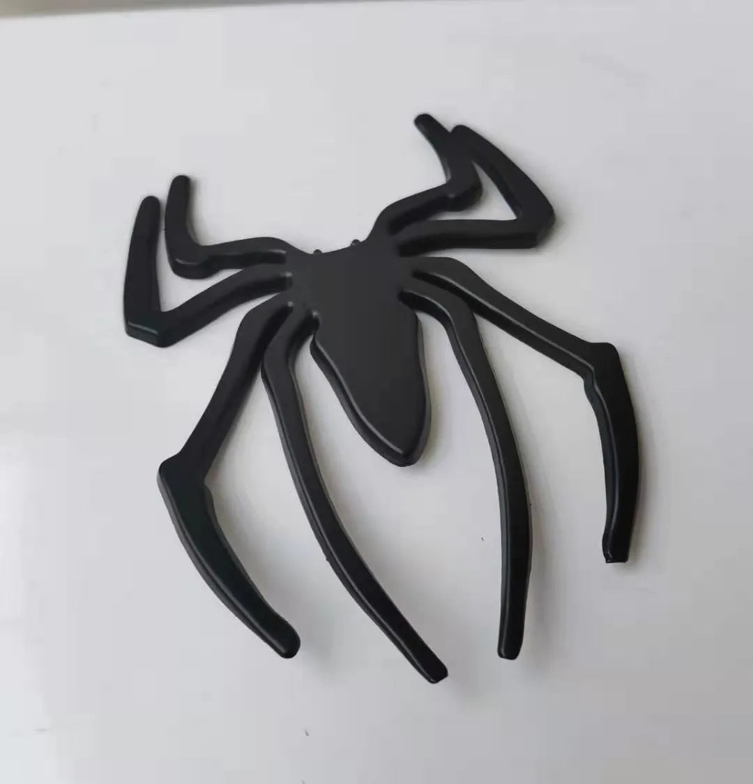 Three-dimensional metal spider car bumper sticker in gold, silver, black, and red colour options.