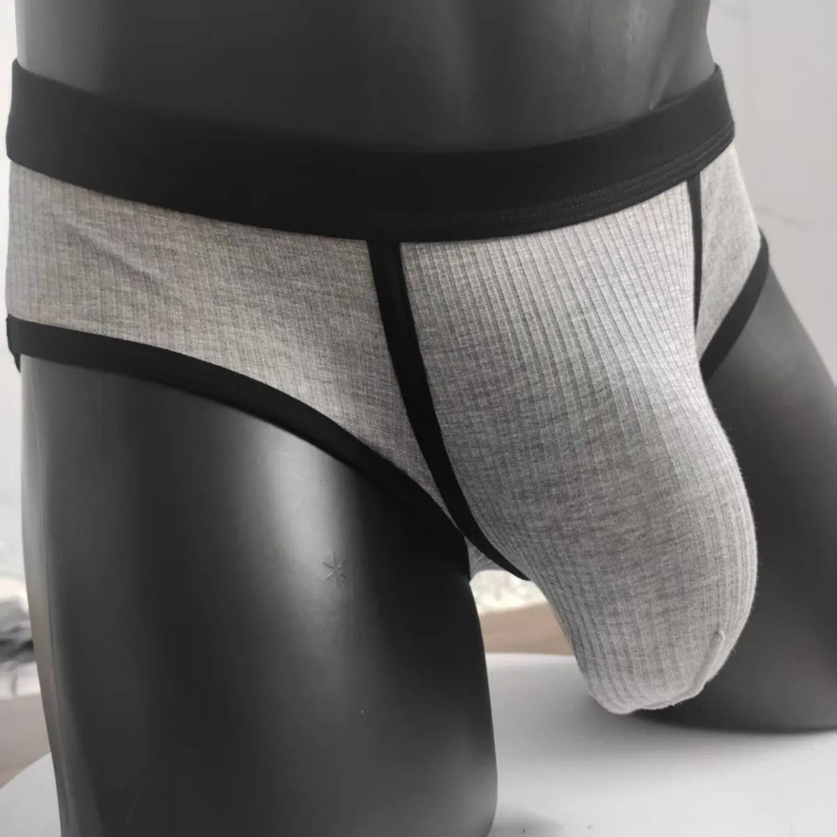 Men's solid colour U-shaped briefs in viscose fabric on a size chart background.