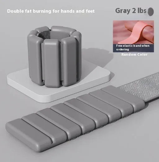 Close-up of a grey detachable weighted fitness bracelet with Velcro strap on a wrist.