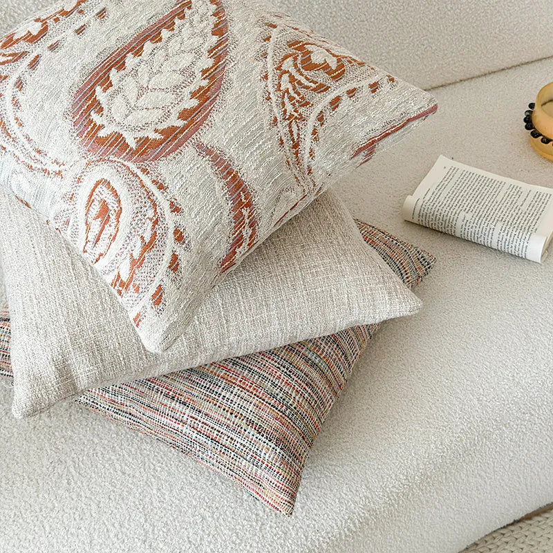 Amber American-style jacquard pillow cover with paisley and flower pattern on a sofa.