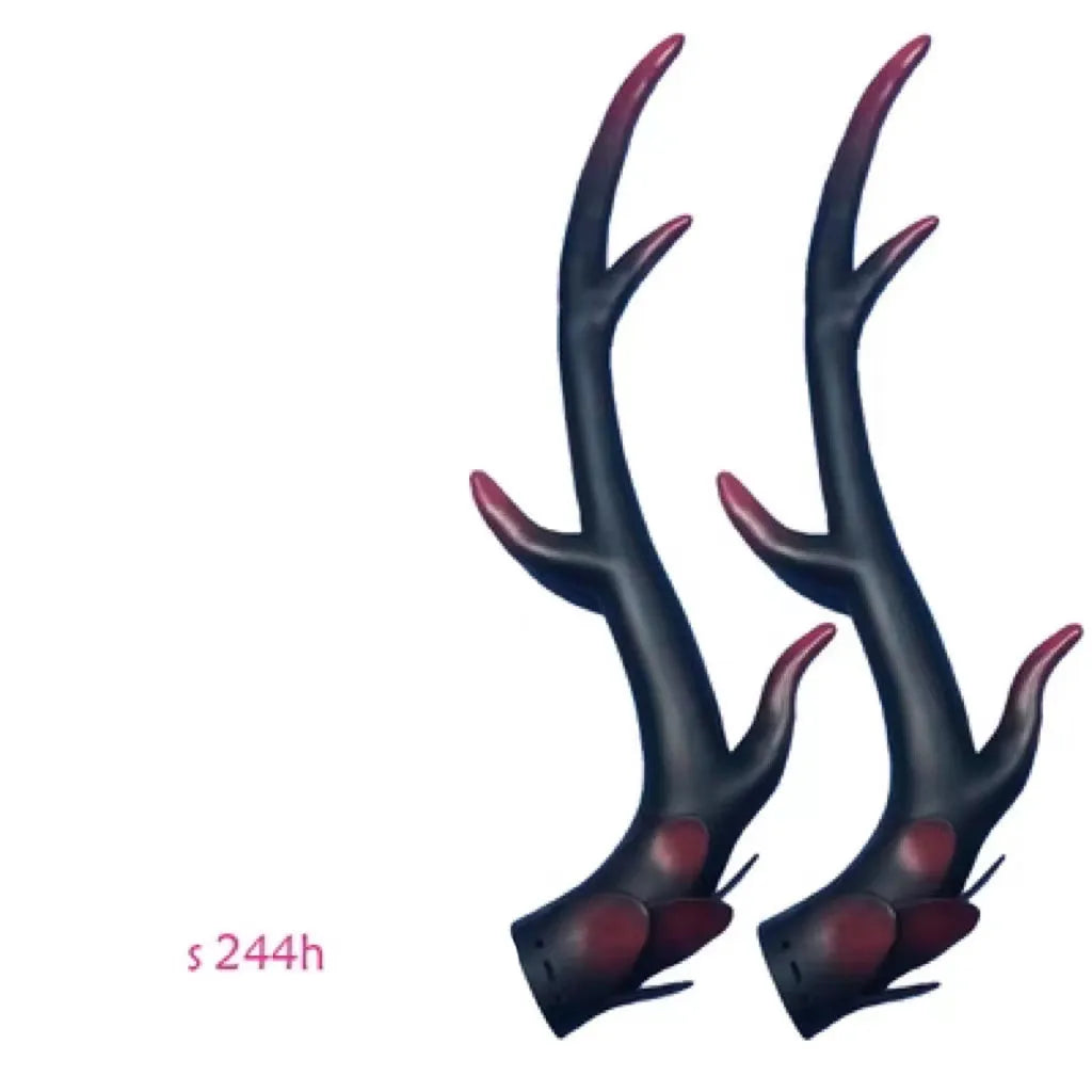 Pair of black resin dragon horn decorations next to a motorcycle helmet, showing scale and detailed texture.