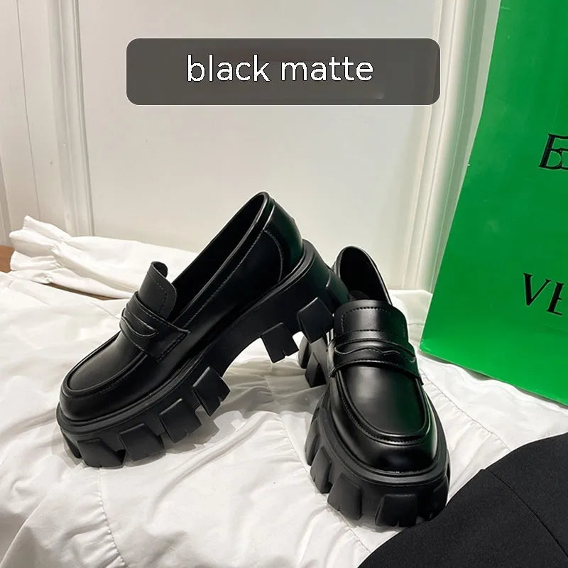 British style wide-fit patent leather loafers with a distinctive muffin heel on a rubber sole.