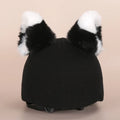 Soft plush cartoon-style decoration sitting on a ski helmet.