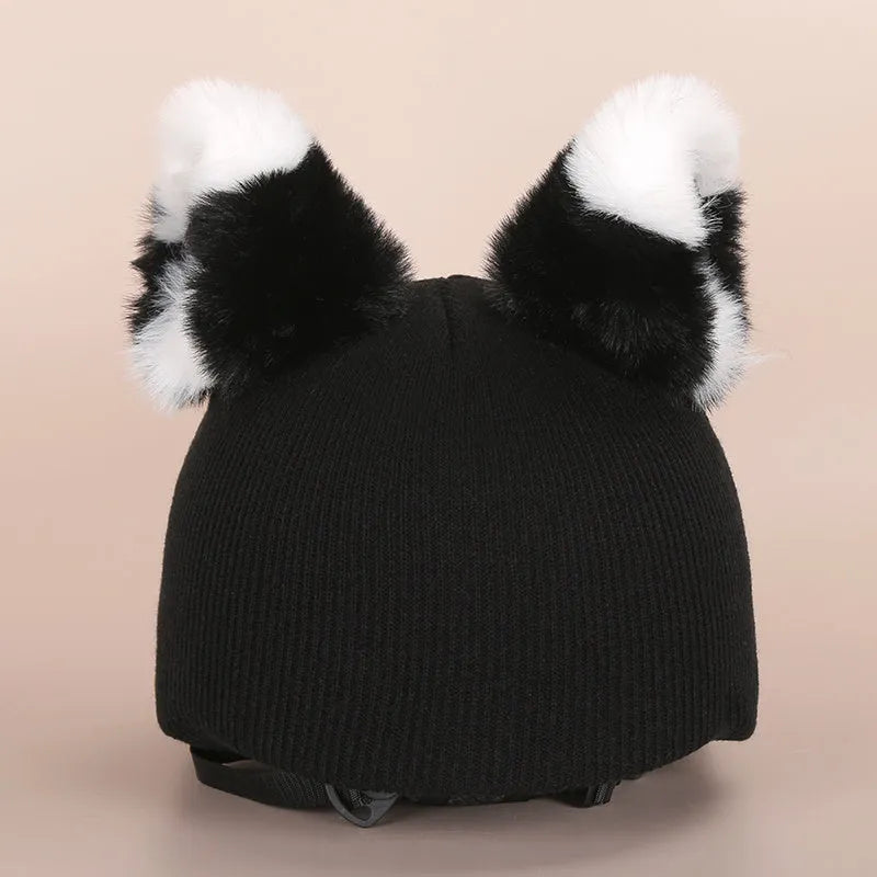 Soft plush cartoon-style decoration sitting on a ski helmet.