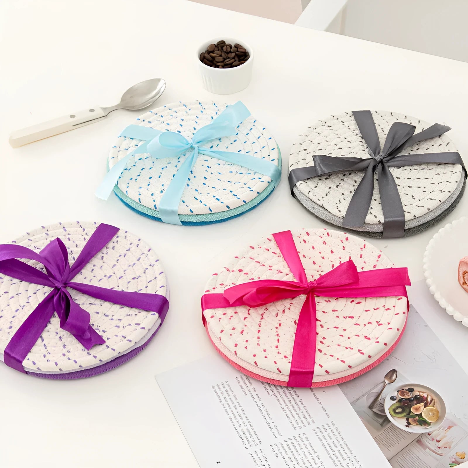 Three round cotton cord coasters in blue, measuring 18cm diameter, on wooden table