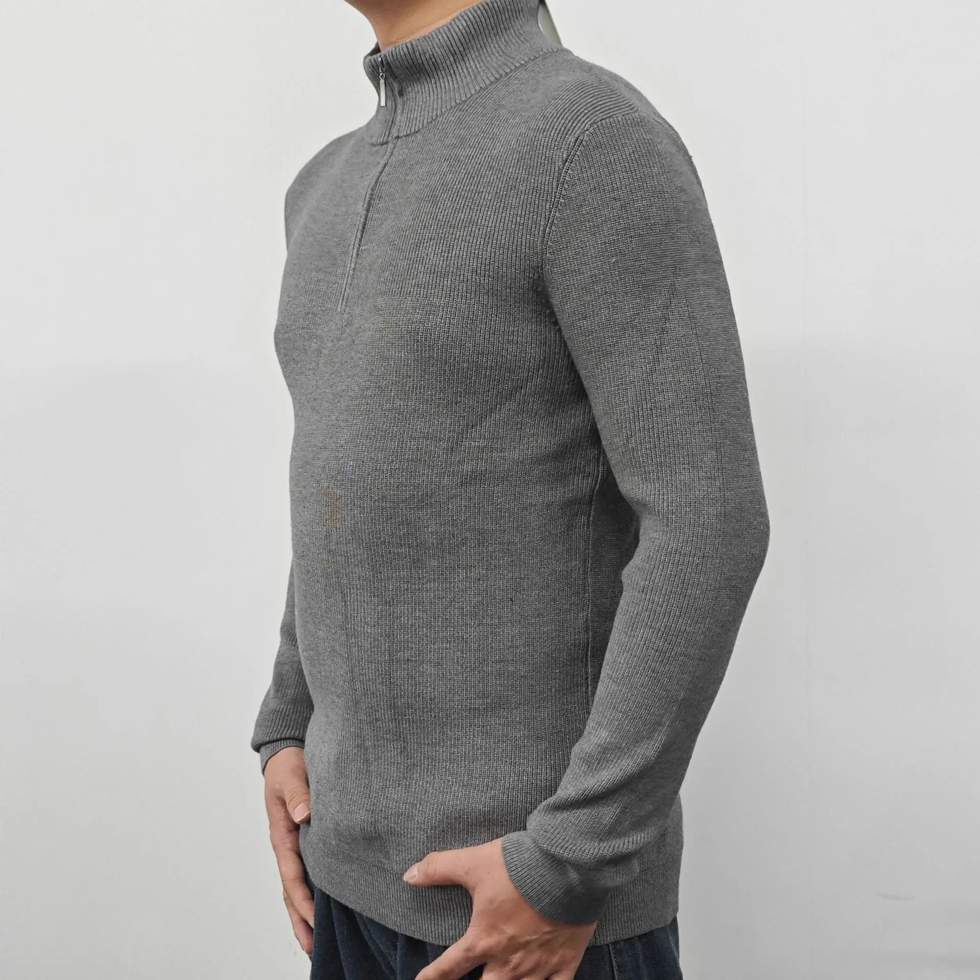 Man wearing a grey zip-front half-turtleneck sweater, a casual long-sleeve pullover.