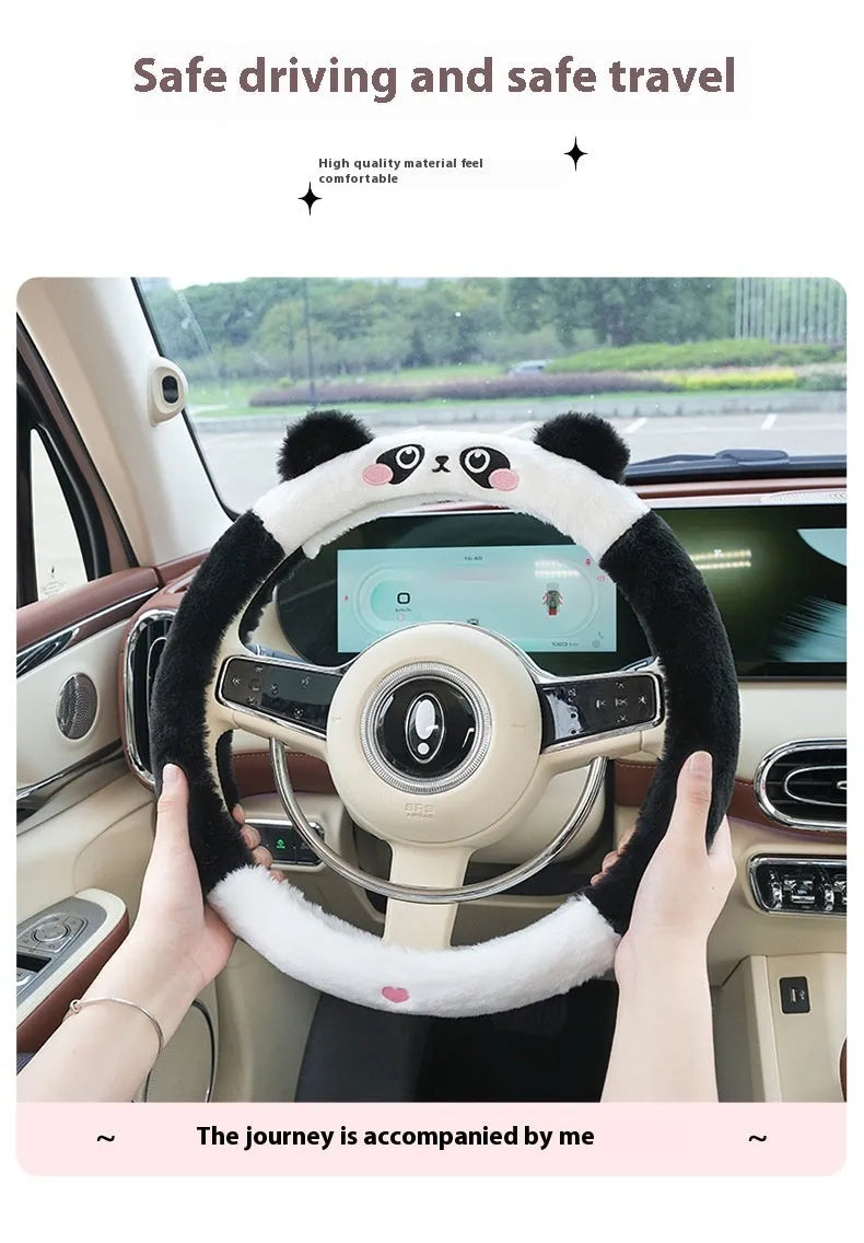 Plush steering wheel cover with embroidered bear design, shown fitted on a car steering wheel.