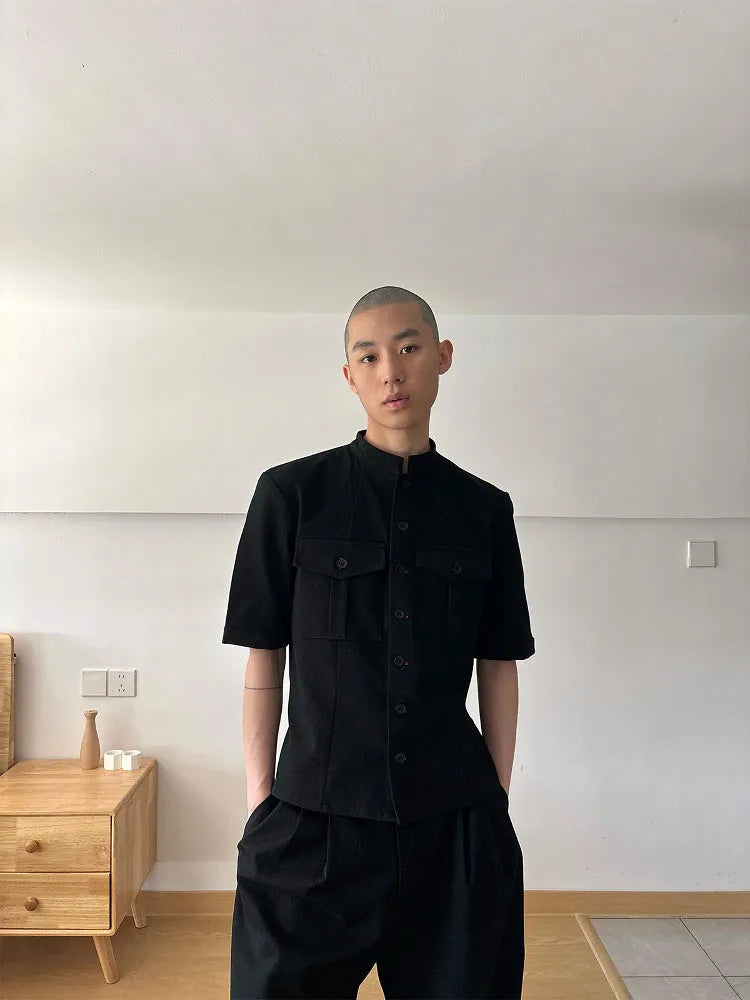 A black loose fit half sleeve hunting shirt with a shirt collar on a hanger.