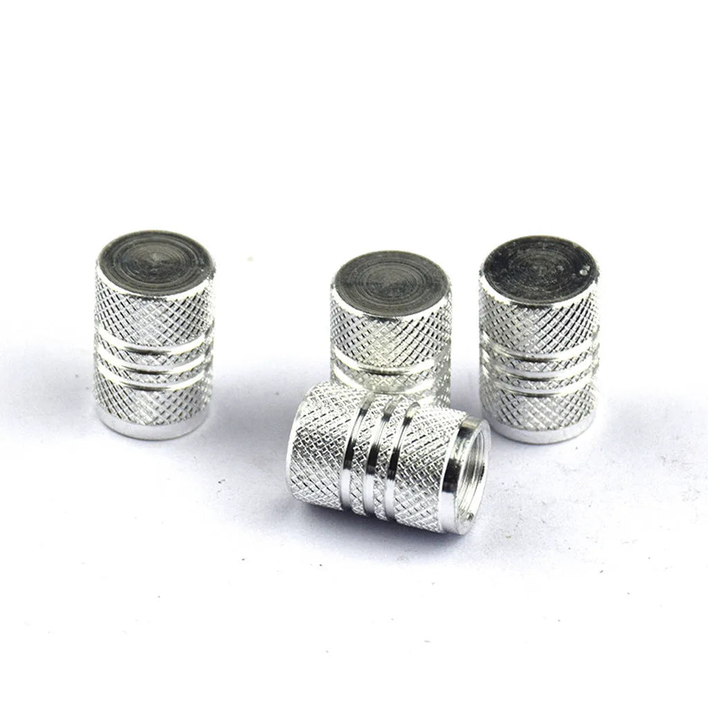 Assortment of aluminium alloy car tyre valve caps in ten different colours on a grey background.