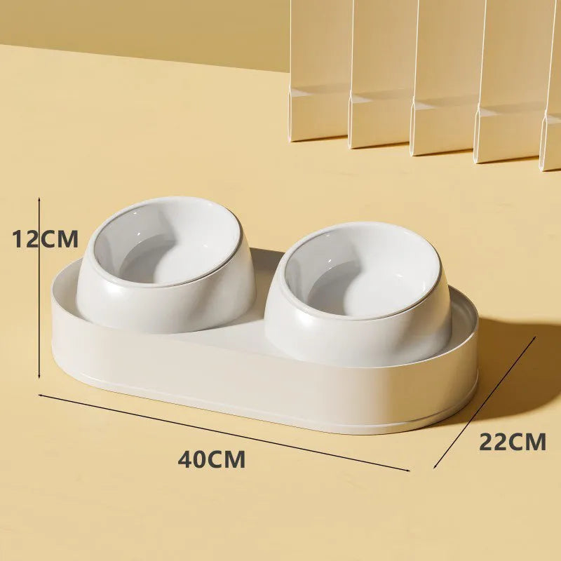 White elevated pet feeder with two tilted bowls on a wide base, for cats and small dogs.
