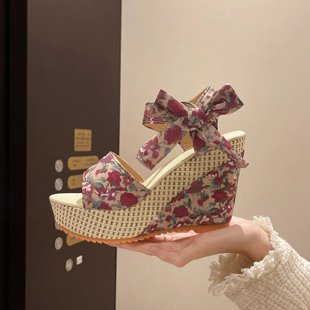 Women's floral wedge sandals with peep toe and adjustable ankle strap buckle.