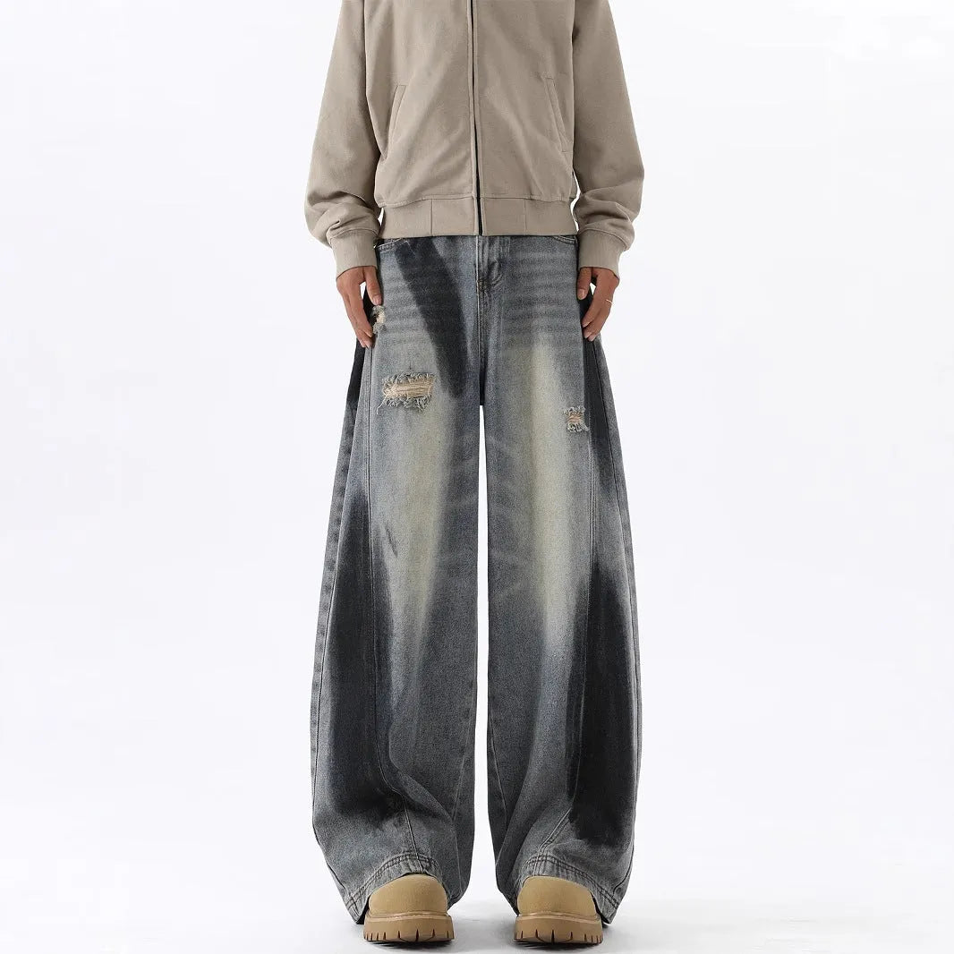 Men's blue ripped jeans with splash-ink design detail showing cotton fabric with micro elasticity