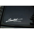 A reflective plastic bumper sticker measuring 16cm by 3.8cm, shown in black, white, and multicolour options.