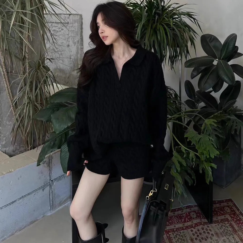 Woman wearing a creamy-white cable-knit long-sleeve sweater and matching elastic-waist knitted shorts from a two-piece set.