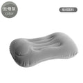 Grey press inflatable travel pillow showing size and flocking texture next to deflated state.