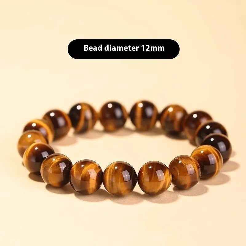 Single circle ethnic Tigereye bead Buddha rosary bracelet on a wrist, showing unisex design.