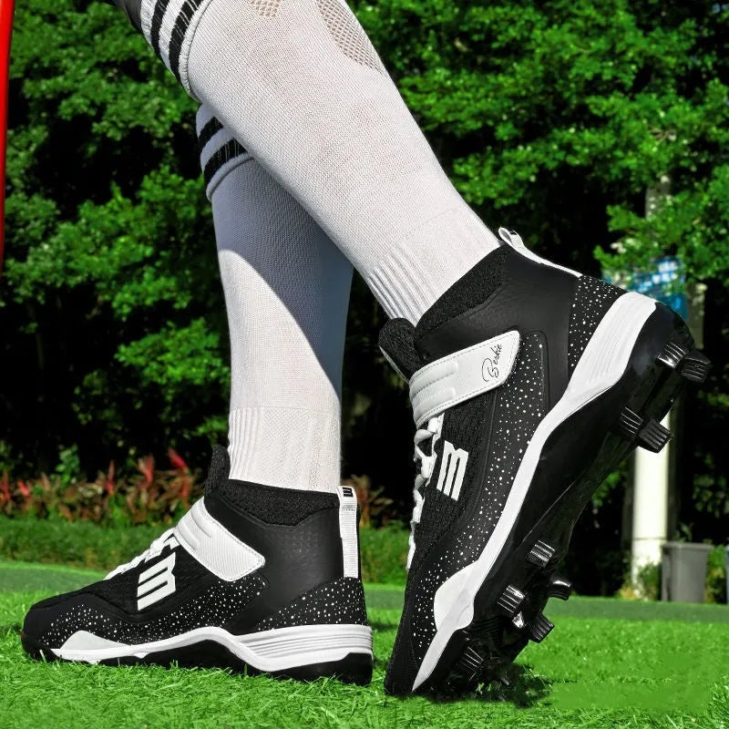 Black and white middle top baseball shoes with Velcro straps and a rubber sole.