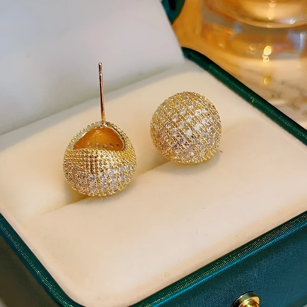 Geometric drop-shaped ear clips with spherical elements in gold and white colour options