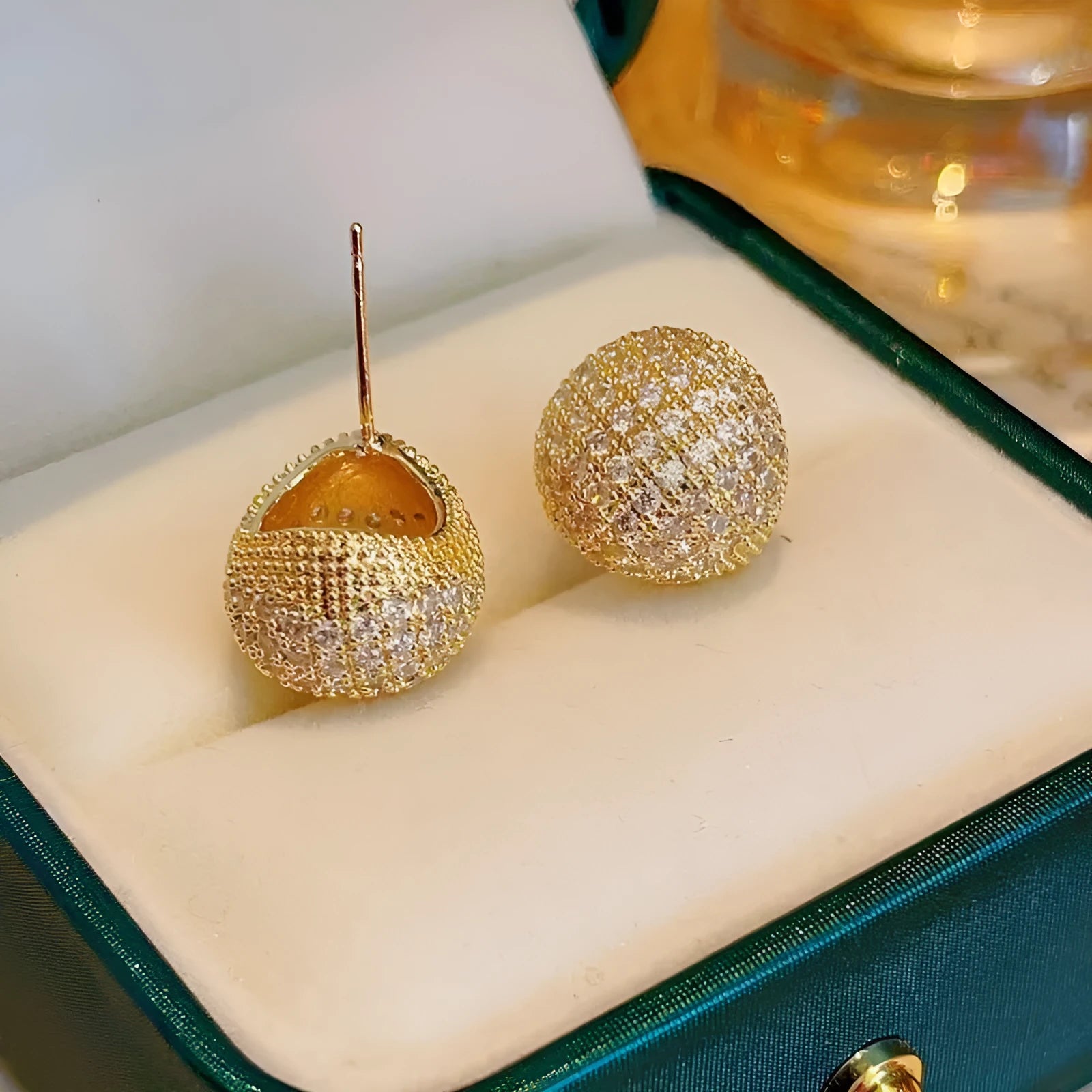 Geometric drop-shaped ear clips with spherical elements in gold and white colour options