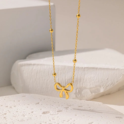 Gold bow necklace on adjustable cross chain for women
