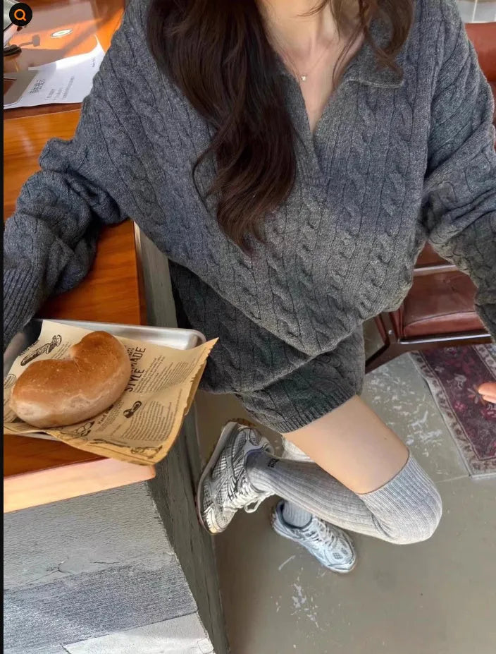 Woman wearing a creamy-white cable-knit long-sleeve sweater and matching elastic-waist knitted shorts from a two-piece set.