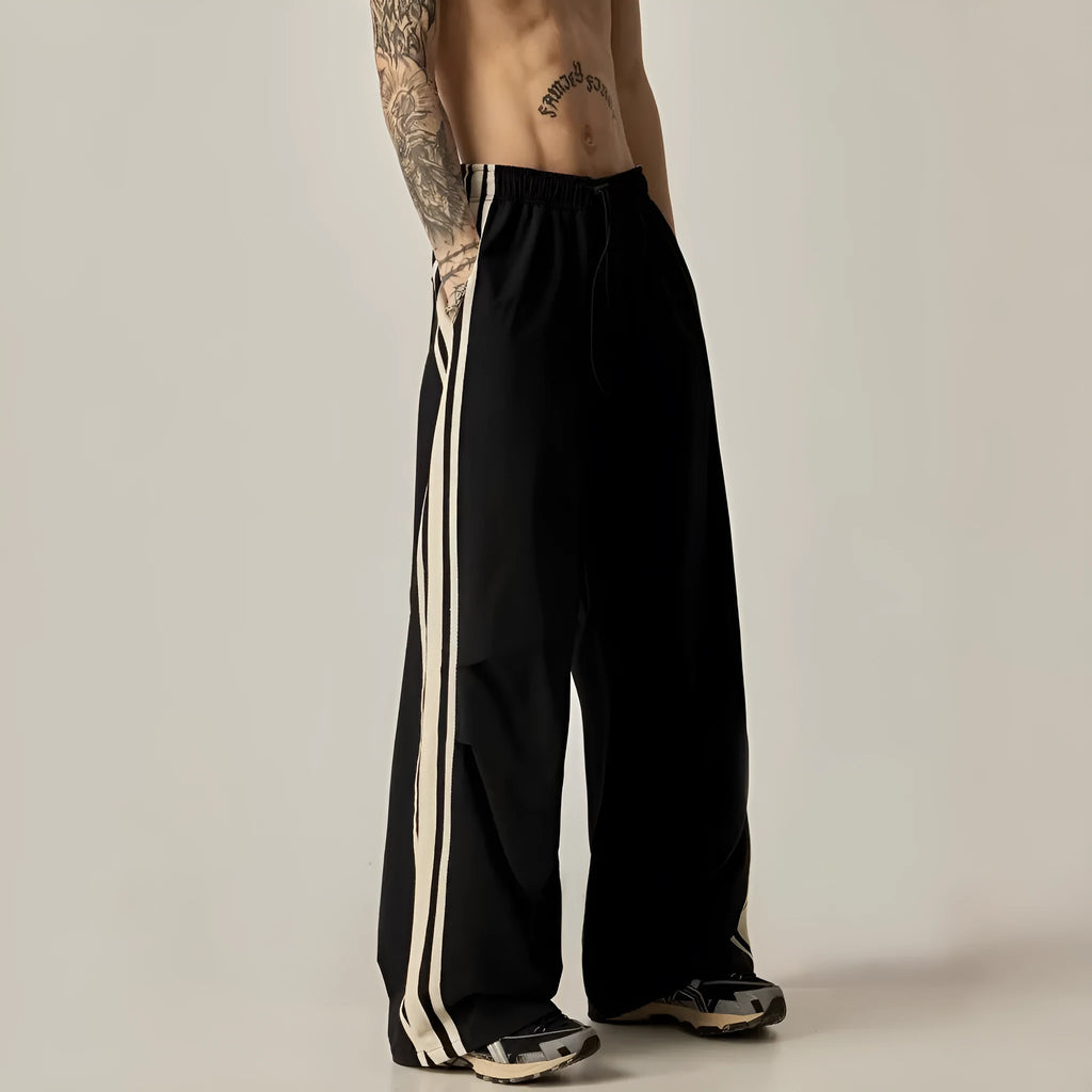Black wide-leg straight-cut men's climbing trousers with a high waist on a hanger.
