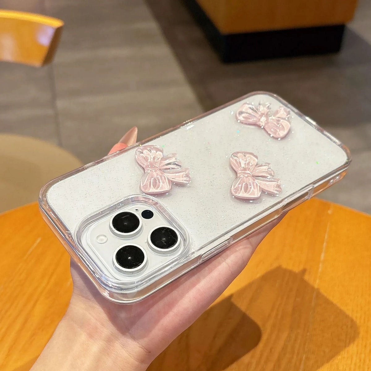 Transparent silicone iPhone case with pink bow knot and clear drop-resistant cover.