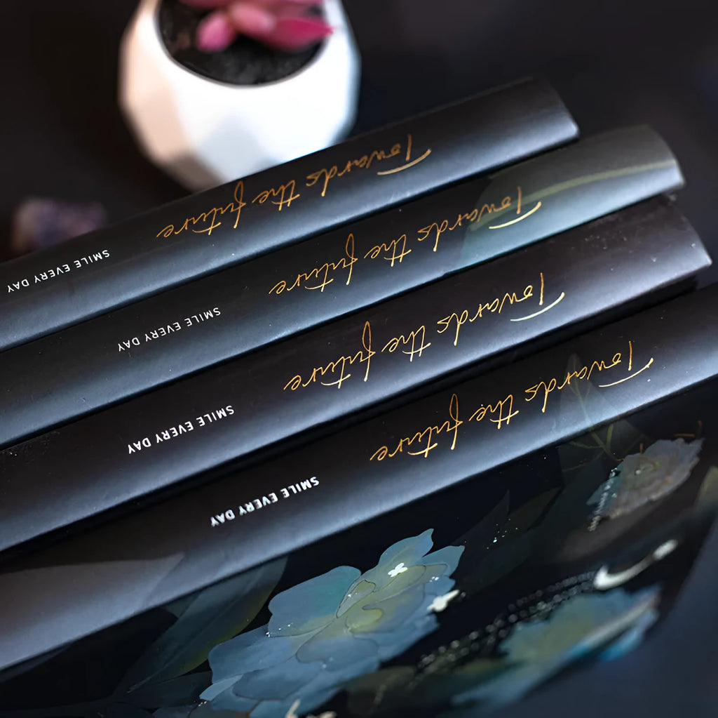 A5 notebook with luminous reflective cover open to show pages with colourful illustrated backgrounds.