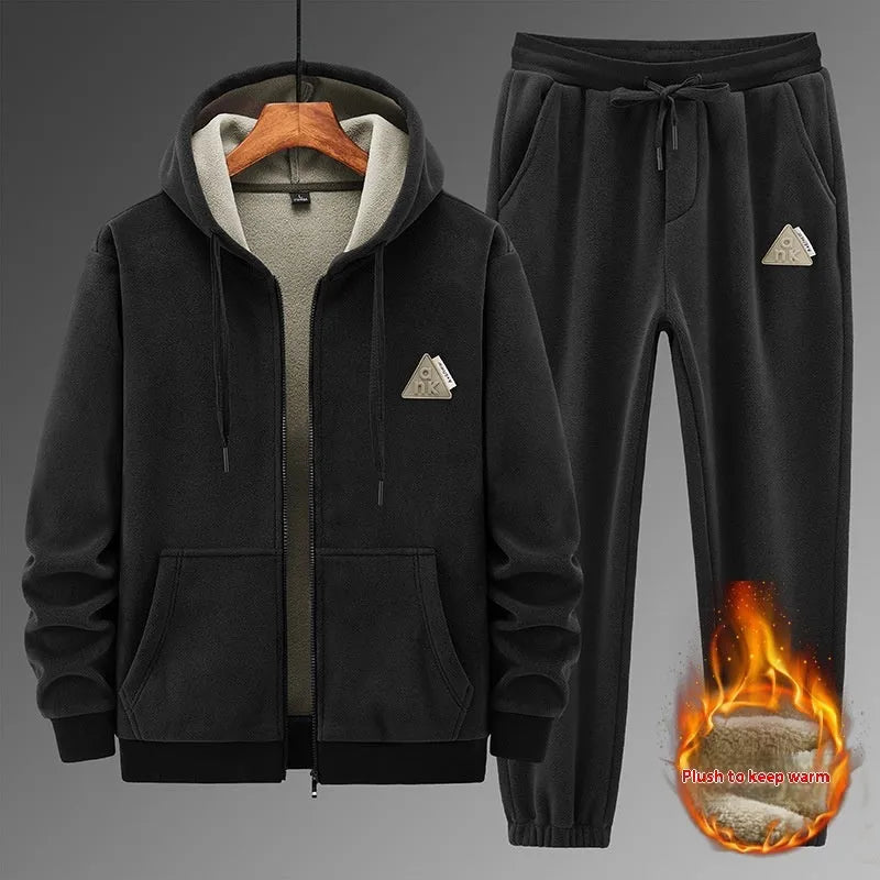 Man wearing a grey hooded sweatshirt and matching tracksuit pants from a casual two-piece set.