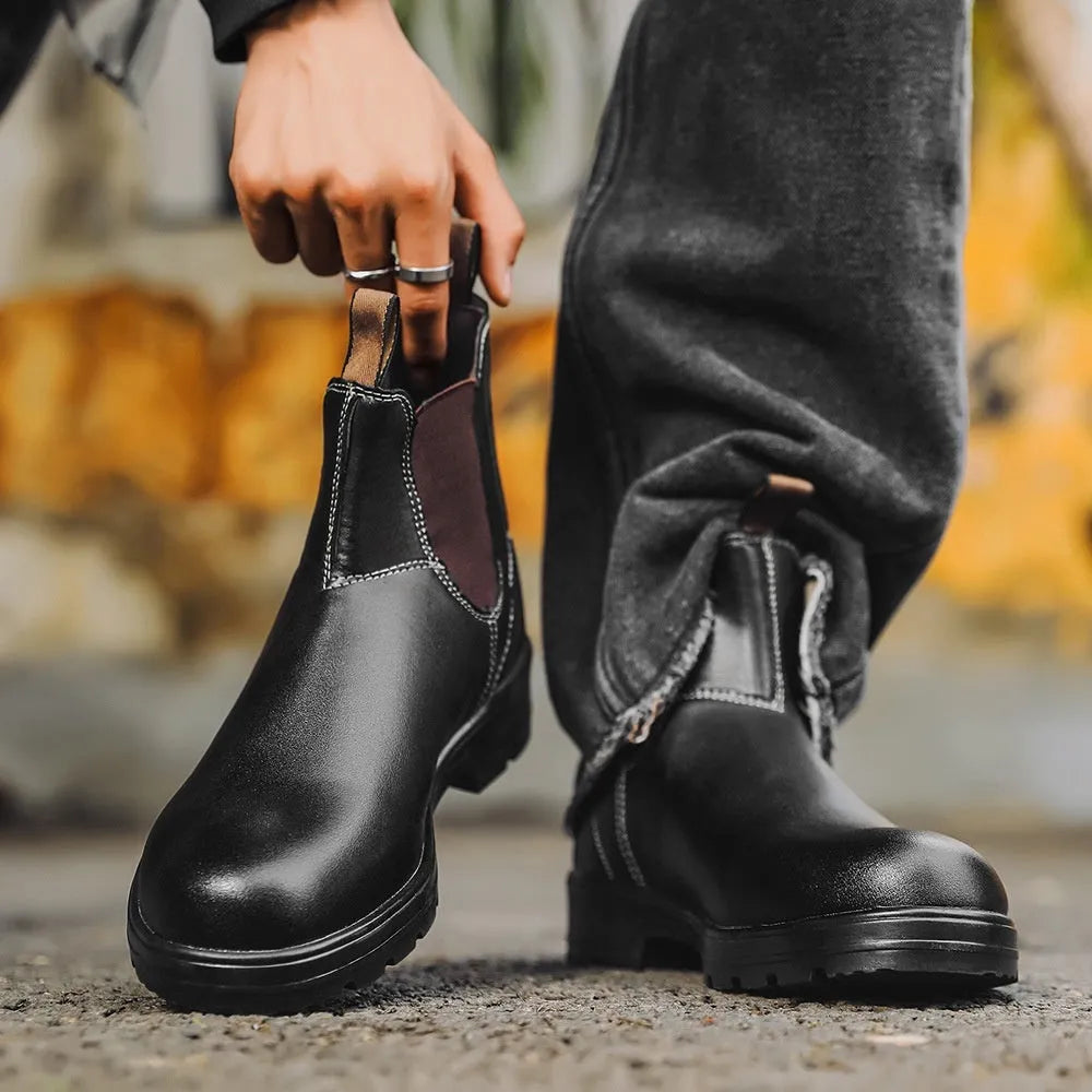 Vintage brown unisex Chelsea boot with frosted PU upper and car suture detailing on a wooden floor.