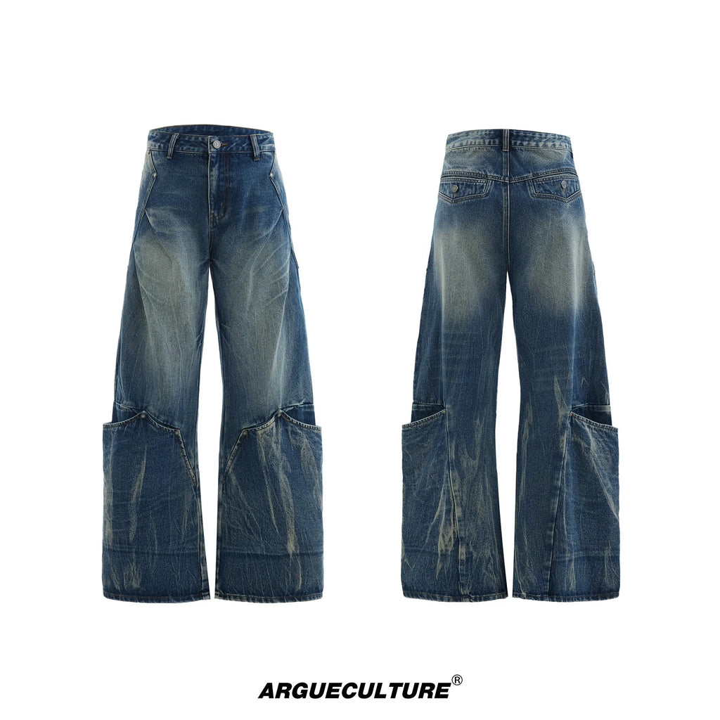 Man wearing verdant blue loose-fit curved knife jeans with a retro washed burst pattern, showing front and side view.