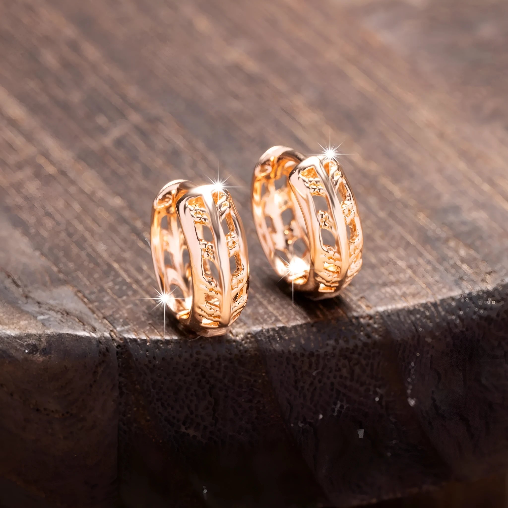 Small copper earrings with hollowed-out leaf and heart shapes in a rose gold colour.