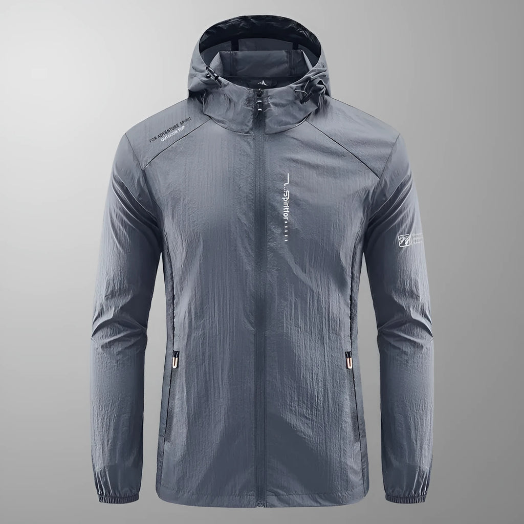 Man wearing a light grey loose-fit hooded nylon summer jacket outdoors.