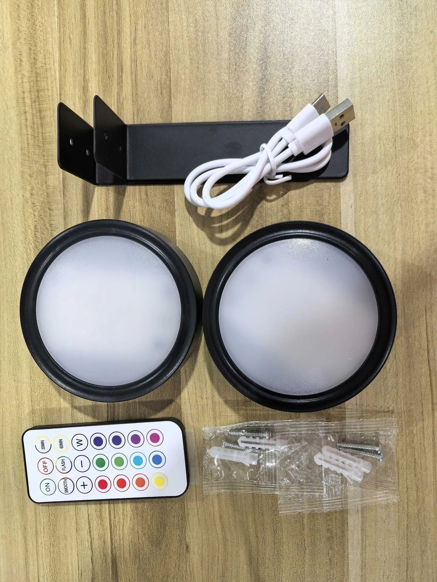 Black magnetic wireless LED lamp with remote control mounted next to a painting on a wall.
