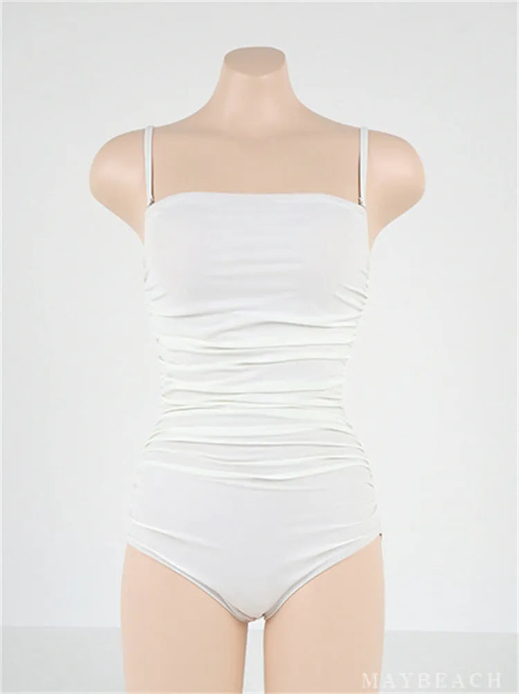 Blue sling style one-piece swimsuit with belly pleating on a model