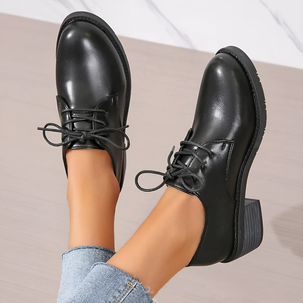 Black women's low-top work shoes with a chunky rubber heel and PU leather upper