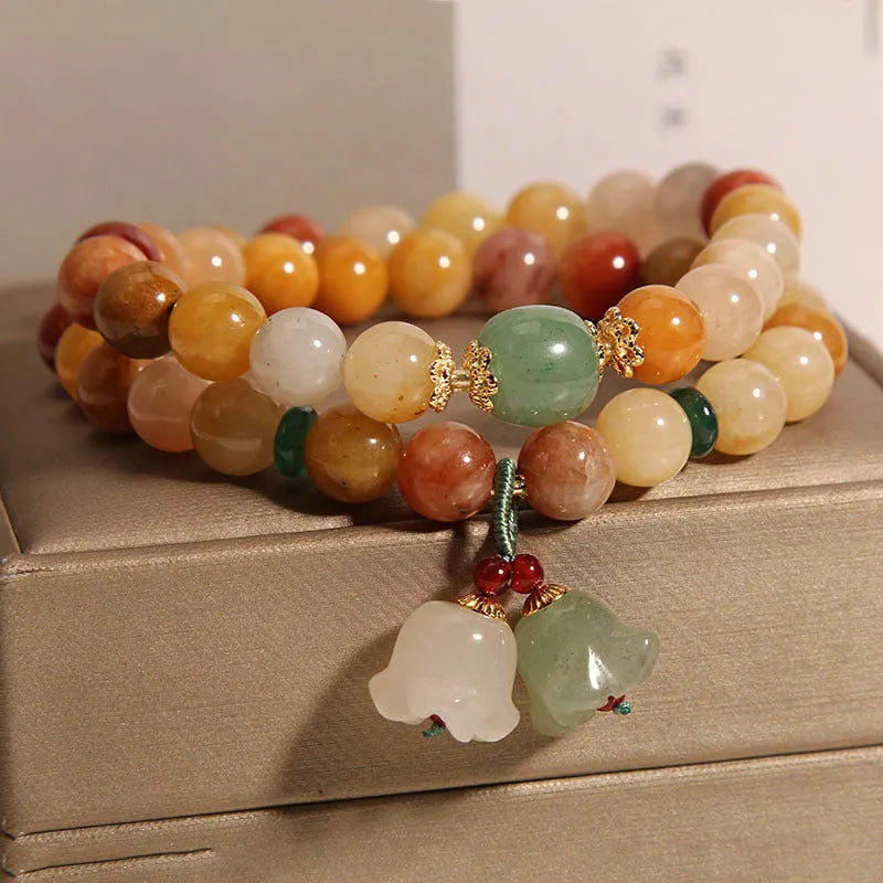 Natural jade multi-strand bracelet for women with an orchid pendant and adjustable clasp.