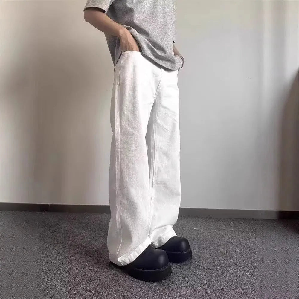Man wearing white straight-leg cotton denim jeans with a wide leg opening.