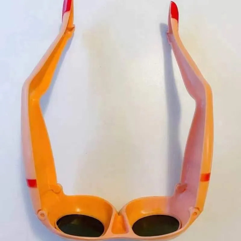 Orange plastic novelty sunglasses with a fun leg and hip design on a white background.