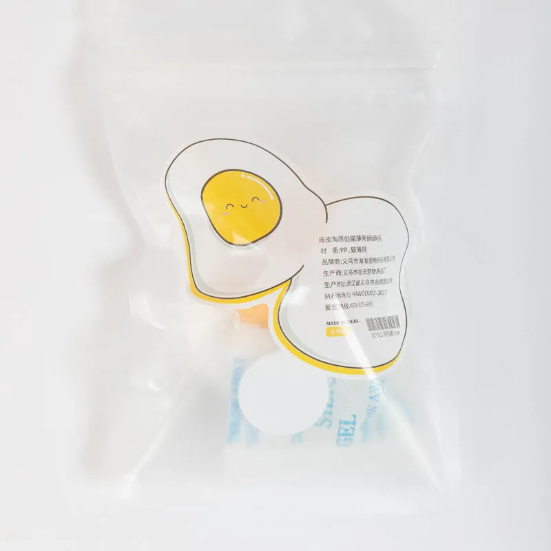 Catnip ball toy with adhesive backing attached to wall, showing cat head shape design